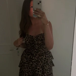 Klänning med volang - Säljer en snygg leopardmönstrad klänning med volangdetaljer.. Klänningen är ärmlös och är väldigt stretchig, skulle säga att den passar xs-m beroende på längd. Köpt på en marknad i Italien, använd endast en gång!! Pris kan diskuteras