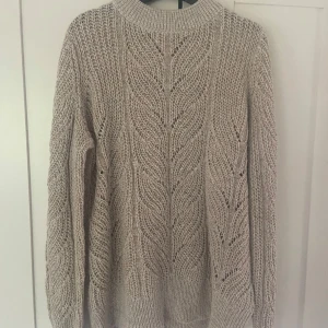Beige stickad tröja från Object - Säljer en beige stickad tröja från Object med snyggt strukturmönster och rund halsringning. Tröjan har knappt använts och ser ut som ny!