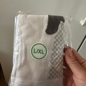 Vita strumpor med pingvinmotiv i storlek L/XL - Säljer ett par vita strumpor med ett coolt pingvinmotiv. Strumporna är förpackade i plast och har detaljer i svart och grått. Perfekt för dig som vill ha något unikt på fötterna.Säljer ett par nya vita strumpor med gråa detaljer. Strumporna är förpackade i plast och har en sportig look. Perfekta för dig som vill ha bekväma och stilrena strumpor till vardags.Kompressionsstrumpor för sport som padel, fotboll, innebandy och löpning. Stabiliserar för minskad smärta och snabbare återhämtning genom fö