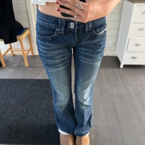 Blå diesel jeans med bootcut💖💖 - Snygga blå jeans med bootcut och låg midja. De har en klassisk femficksdesign och en knappdetalj vid midjan. Perfekta för en avslappnad stil.