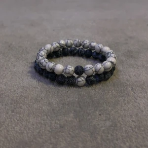 Dubbelradigt armband med marmorering - Snyggt dubbelradigt armband med vita och blåa marmorerade pärlor. Perfekt för att ge en stilren touch till din outfit. Elastiskt band för enkel passform.