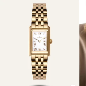 Guldfärgad klocka från Mockberg - Säljer elegant guldfärgad klocka från Mockberg med rektangulär urtavla och romerska siffror. Armbandet är i metall med en klassisk länkdesign. Perfekt för en stilren look. Kan även tänka mig byta klockan på första bilden som jag har till andra! Hör av er om ni är intresserade! 