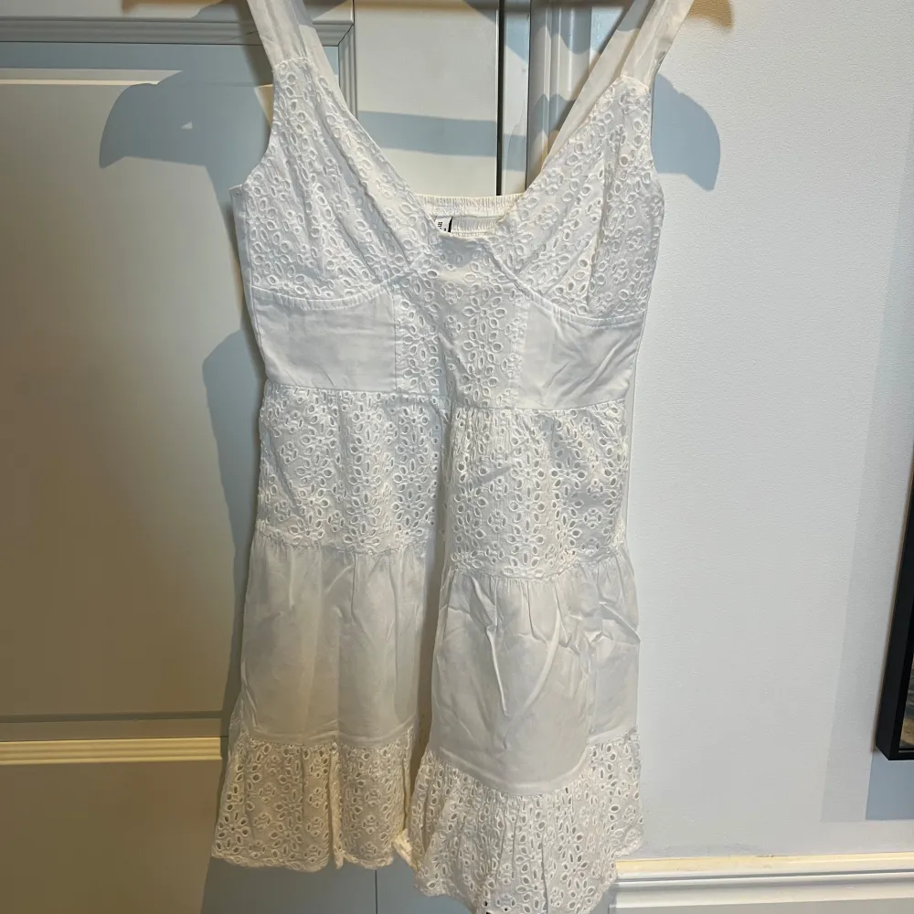 Söt vit klänning från Stradivarius med broderade detaljer och volangkant. Använd några få gånger. Passar super bra som studentklänning. Storlek XS.. Mekot.