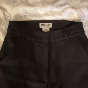 svarta kostymbyxor från madlady - snygga svarta kostymbyxor från Madlady i en stilren design. byxorna har en klassisk passform. midjan är i storlek 32 och längden är 28. de sitter nästintill perfekt på mig som är 156 cm, aningen för långa. de är rätt så noppriga men det går lätt bort. kom privat vid intresse!💕