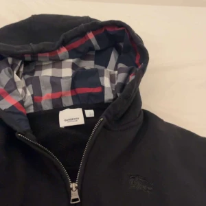 Burberry Kofta - Säljer min burberry kofta som jag fick i present för att den passar inte o den ligger bara i garderoben. Den är använd 2 gånger max. Pris kan sänkas vid snabb affär. Möts bara upp i göteborg!!!!