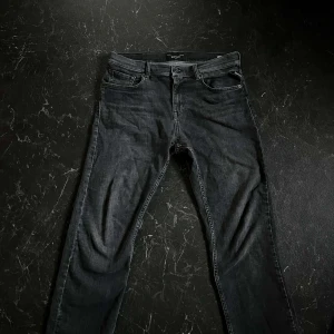 Svarta jeans från Replay - Snygga svarta jeans från Replay med en klassisk femficksdesign. De har en knappgylf och är tillverkade i ett slitstarkt material som ger en stilren look. Perfekta för en avslappnad men ändå stilfull stil. De är barnstorlek så därför är de 16a men är rätt stora