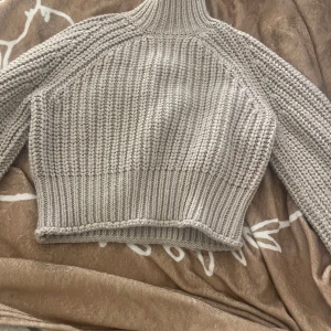  stickad tröja - En stickad tröja från h&m som är lite croppad o har en hög krage, ny pris 400kr