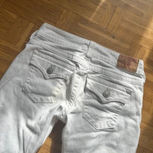 True religion jeans - Sjukt snygga bootcut lowwaist true religion byxor som tyvärr inte passar!! De är oanvända men har en sjukt liten missfärgning, se sista bilden. Storlek 28. Det är bara att fråga ifall du undrar över något!!💗   Mått: Mått: 37cm rakt över midjan, 78cm innerbenslängd, 98cm full längd, 20cm grenhöjd 