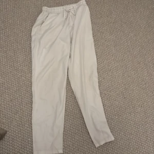 Vita mjukisbyxor med snörning Shein - Säljer ett par bekväma vita mjukisbyxor med elastisk midja och snörning. Perfekta för en avslappnad stil.