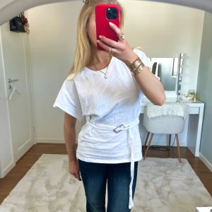 Vit knytblus - Säljer en stilren vit t-shirt med knytband i midjan. Tröjan har korta ärmar och en rund halsringning. Perfekt när man vill klä upp sig💘 från Zara i storlek S