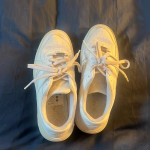 Vita Nike Air Force sneakers - Säljer ett par klassiska vita Nike Air Force sneakers. De har en stilren design med snörning och en robust sula. Perfekta för en casual look.  Storlek 39. Knappt använda. Kmr gengöras innan skickas iväg. 