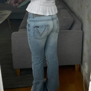 Ljusblå bootcut jeans - Snygga ljusblå bootcut jeans med låg midja och klassisk femficksdesign. Jeansen har en diskret tvätt och dekorativa sömmar på bakfickorna. Perfekta för en avslappnad stil. Midjemåttet 37cm och innerbenslängd 83cm💗