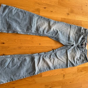 Utsvängda jeans från ONLY - Ljusa, utsvängda jeans från ONLY. Låg midja. Jeansen har klassiska fem fickor, dragkedja och knapp framtill. 