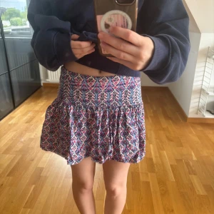  kortkjol från Zara - Supersöt kortkjol från Zara med mönster i blått, rosa och vitt. Kjolen har volang nertill och dragkedja i sidan. Perfekt för dig som gillar färg och mönster! Storlek 164, skulle säga den motsvarar en XXS/XS