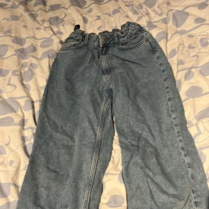 Ljusblå loose fit jeans från H&M - Säljer ett par ljusblå jeans från H&M med loose fit och rak passform. Byxorna har resår i midjan och stora bakfickor. Perfekta för en avslappnad stil och enkla att matcha med olika toppar.