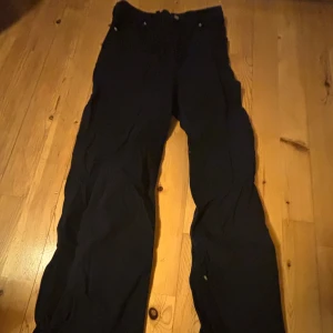 Svarta byxor från Divided - Svarta byxor från Divided med klassisk passform och raka ben. Byxorna har normal midja och är tillverkade i ett bomullsmaterial med lite stretch. Perfekta för en stilren look.
