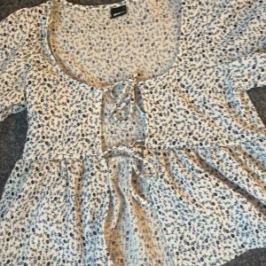 Blommig blus med knytning från Gina Tricot - Supersöt blus ifrån Gina, perfekt för sommaren. Inte använts något 😅 säljs för 50kr 