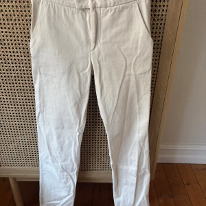 Vita kostymbyxor från Isabel Marant - Snygga vita kostymbyxor från Isabel Marant med klassisk passform och diskret midjedetalj. Byxorna har raka ben och är tillverkade i ett mjukt bomullsmaterial. Perfekta för en stilren och trendig look.