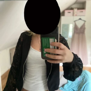 Svart bomberjacka med spetsärmar  - Säljer en super snygg svart bomberjacka från Little Mistress med unika spetsärmar och dragkedja framtill. Ärmarna har spets på sig. Perfekta vår och sommar jackan! Passar xs-s