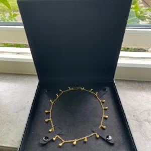 Sirens Tears Necklace från Maria Nilsdotter - Väääärldens snyggaste och coolaste halsband i guld från Maria Nilsdotter, Sirens Tears Necklace. Halsbandet har små droppformade hängen längs hela kedjan som ger ett unikt och stilrent uttryck. Använd 1 gång! Passar när som och man kan klä upp den och ner den. Original pris 5100 kronor. Skriv för frågor!