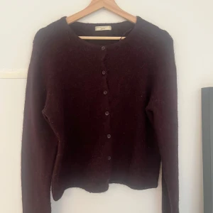 Vinröd kofta från Gina Tricot - Mysig vinröd kofta från Gina Tricot med rund halsringning och knäppning framtill. Tröjan är stickad och har långa ärmar, perfekt för lager-på-lager under kyligare dagar.