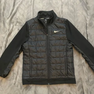 Svart Nike cardigan - Säljer en svart cardigan jacka från Nike Therma-Fit med dragkedja och lång ärm. Skulle säga att den passar bra om man är 160-168 cm. Den är sparsamt använd och i mycket bra skick. Skriv för frågor eller fler bilder. Priset går nog att diskutera.