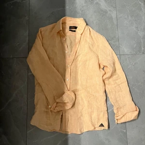 Morris Linneskjorta  - Säljer den här riktigt snygga Morris linneskjorta i aprikos. Den är i bra skick och är perfekt till sommarn. Den är storlek Xs men sitter som S. Skriv vid minsta fråga/fundering!