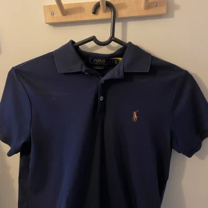 Pikétröja från Ralph Lauren - Mörkblå pikétröja från Polo Ralph Lauren. Använd fåtal gånger och kan ej lämna tillbaka den längre, skriv vid frågor!