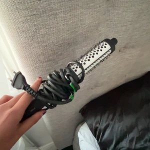 Rundborste med värme - Elektrisk rundborste med keramisk yta och svarta piggar. Perfekt för att styla och ge volym till håret. Borsten har ett svart handtag och en lång sladd med EU-kontakt.