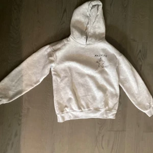 Grå hoodie med tryck 'MA CHÉRIE' och stjärna - Säljer en ljusgrå hoodie med huva och trycket 'MA CHÉRIE' samt en stjärna på bröstet, från Gina tricot Young. Banden har dock tyvärr åkt av och vet inte vart de är,  men annars är den i bra skick 💕 köpare står för frakt!!📦 