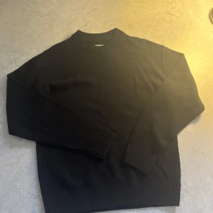Svart stickad tröja med rund hals - Svart stickad tröja från jack & jones. Storlek M men passar L också. Använd 1 gång.