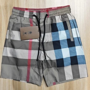 shorts från Burberry - Snygga shorts från Burberry i klassiskt rutigt mönster med beige, blå, röd och vit färg. Shortsen har elastisk midja med svart snörning och sidofickor. Perfekta för sommaren och strandhäng.