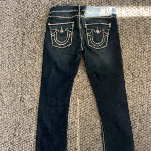True Religion Low Waist Jeans  - Säljer dessa ursnygga jeans från True Religion i storlek 30 🩵 Låg midja och rak modell  Midjemått (rakt över midjan): 41 cm Innerbenslängd: 85 cm  Köpta på Sellpy för 1300 kr, men har tyvärr aldrig kommit till användning. Mycket fint skick! Passa pååååå