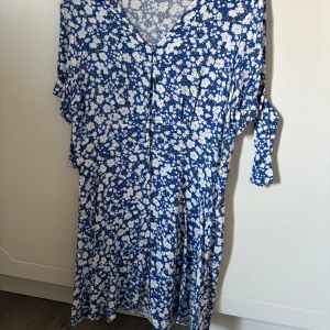 Sommrig klänning - Säljer denna klänning som var tänkt till midsommar men var för liten. Mer en 36 än 38. Superfin med knappar och knyten som blir rosetter på armarna 