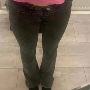 low waist jeans - Snygga svarta jeans med slitningar på låret. De har en tight passform och är perfekta för en trendig look. Jeansen har klassisk femficksdesign och knappgylf. DE ÄR LOWWAIST  