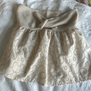 Beige topp med spetsdetaljer från Shein - Söt beige  topp från Shein med ett stickat midjeband och vackra spetsdetaljer i blommönster. Toppen har en omlott-design upptill och är gjord i polyester. Perfekt för en somrig look! Nyskick!!!