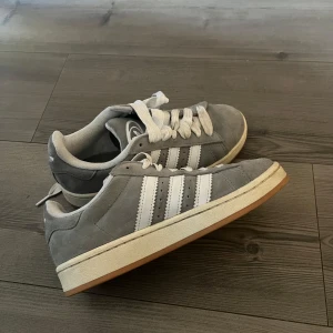 Grå Adidas Campus sneakers - Snygga grå Adidas Campus. Fick som present men knappt använda då de var lite stora. Storlek 37,5. Inga defekter alls och inga tecken på användning. 