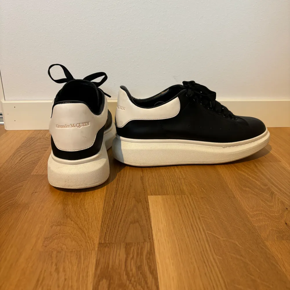 Säljer ett par svarta sneakers från Alexander McQueen med vit häl och tjock vit sula. Skorna har snörning och rund tå, klassisk design och är tillverkade i skinn. Perfekta för dig som gillar stilrena och trendiga sneakers. De är nytvättade. Kommer med dustbag.. Kengät.