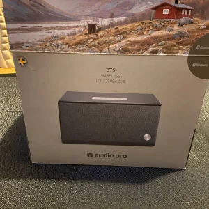 Trådlös högtalare BT5 från Audio Pro - Säljer en stilren trådlös högtalare BT5 från Audio Pro. Den har en elegant design med svart tyg och en diskret logotyp. Perfekt för att streama musik via Bluetooth. Kommer i originalförpackning med alla tillbehör. Ny pris 1600 mitt pris 1200