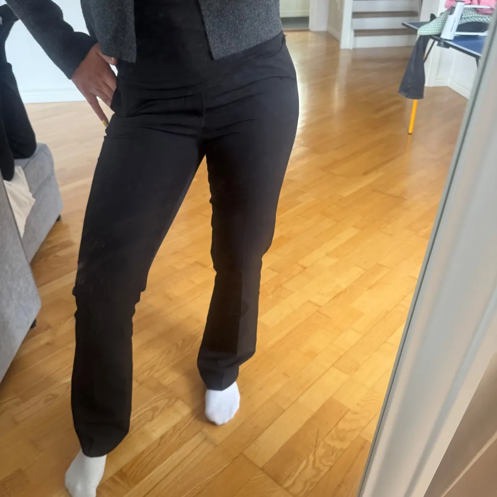 Snygga svarta byxor med hög midja och rak passform. Perfekta för en stilren look. Byxorna har en klassisk design och är lätta att matcha med olika toppar.. Farkut & Housut.