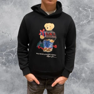 Ralph Lauren Polo Bear Hoodie svart - •Ralph Lauren Polo Bear christmas-present Hoodie svart. Skick: 8-9/10; inga skador! Storlek: 14/16 år = XS~. •Mått, axel-neråt: 55 cm, bredd: 44 cm. Modell: 173 cm, 65 kg. Sitter lite för litet på modell på bild! Authentic: ✅; QR Kod finns även i plagget. Hör av dig vid frågor eller funderingar; mvh Hessler’s;)