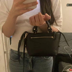 Handväska från h&m - Jätte fin och Classy handväska från h&m med guld detaljer, inga skador knappt använd 