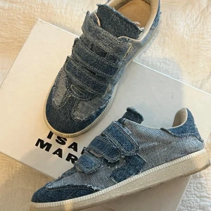 Blå sneakers från Isabel Marant - Snygga blå sneakers i jeansmaterial från Isabel Marant. Skorna har tre kardborreband för enkel justering och en bekväm sula. 