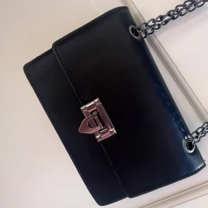 Svart axelväska med kedjerem - Svart väska med mörka kedjeremmar.