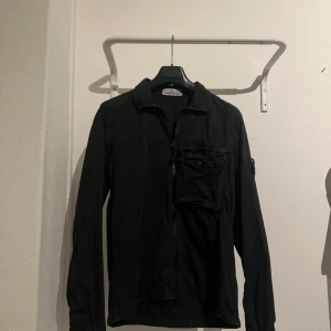 Svart overshirt från Stone Island -  Hej, säljer min stone island overshirt då den inte passar nå mer. Ett perfekt plagg till vår och sommar! Skriv privat om ni har några andra frågor angående overshirten! 