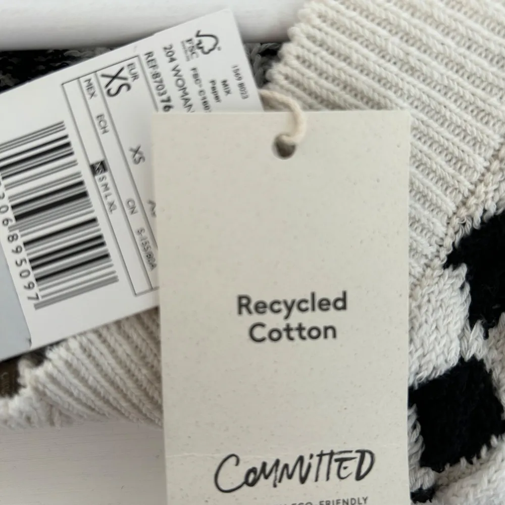 Säljer en hundtandsmönstrad väst från Mango. Västen har v-ringning och breda ribbade kanter. Tillverkad i återvunnen bomull, perfekt för lager-på-lager-stil. Material: polyester 56%, bomull 42%, viskos 2%. Neuleet.