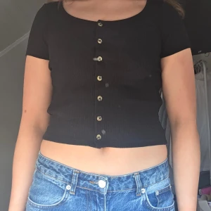 Svart ribbad kortärmad topp - Säljer en svart ribbad topp från monki, knappt använd.