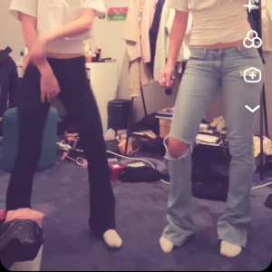 Ljusblå bootcut jeans med slitna knän - Säljer ett par ljusblå bootcut jeans med slitningar och hål på knäna. Jeansen har låg midja. Perfekta för dig som gillar en avslappnad och trendig stil. Lite slitna nere vid foten men inget som syns på mig som är 168