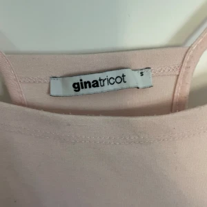 Ljusrosa klänning från Gina Tricot - Säljer en söt ljusrosa klänning från Gina Tricot. Klänningen har smala axelband och en enkel, elegant design som passar perfekt för varma dagar. Den är tillverkad i ett mjukt material som ger en bekväm och snygg passform.