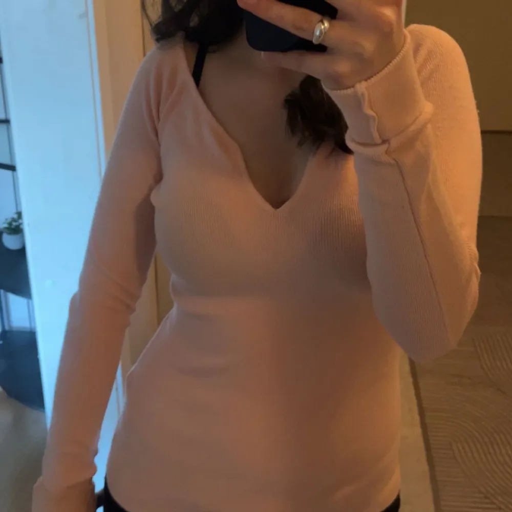 SÀljer en stilren beige ribbad tröja med v-ringning och lÄnga Àrmar. Perfekt för en avslappnad men ÀndÄ chic look. Passar bra till bÄde jeans och kjol.. Neuleet.